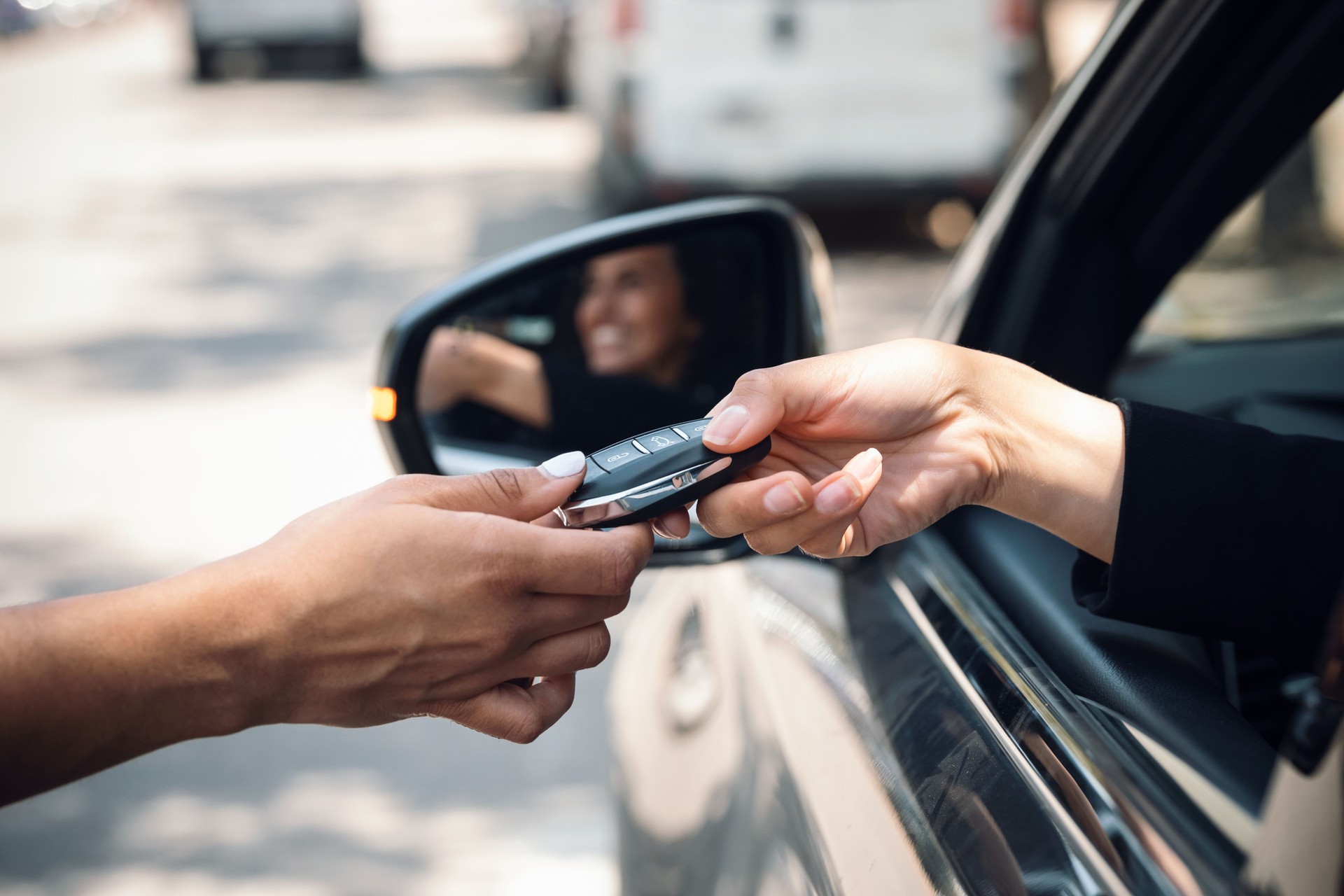 Car rental agency employee giving car keys to beautiful young woman.